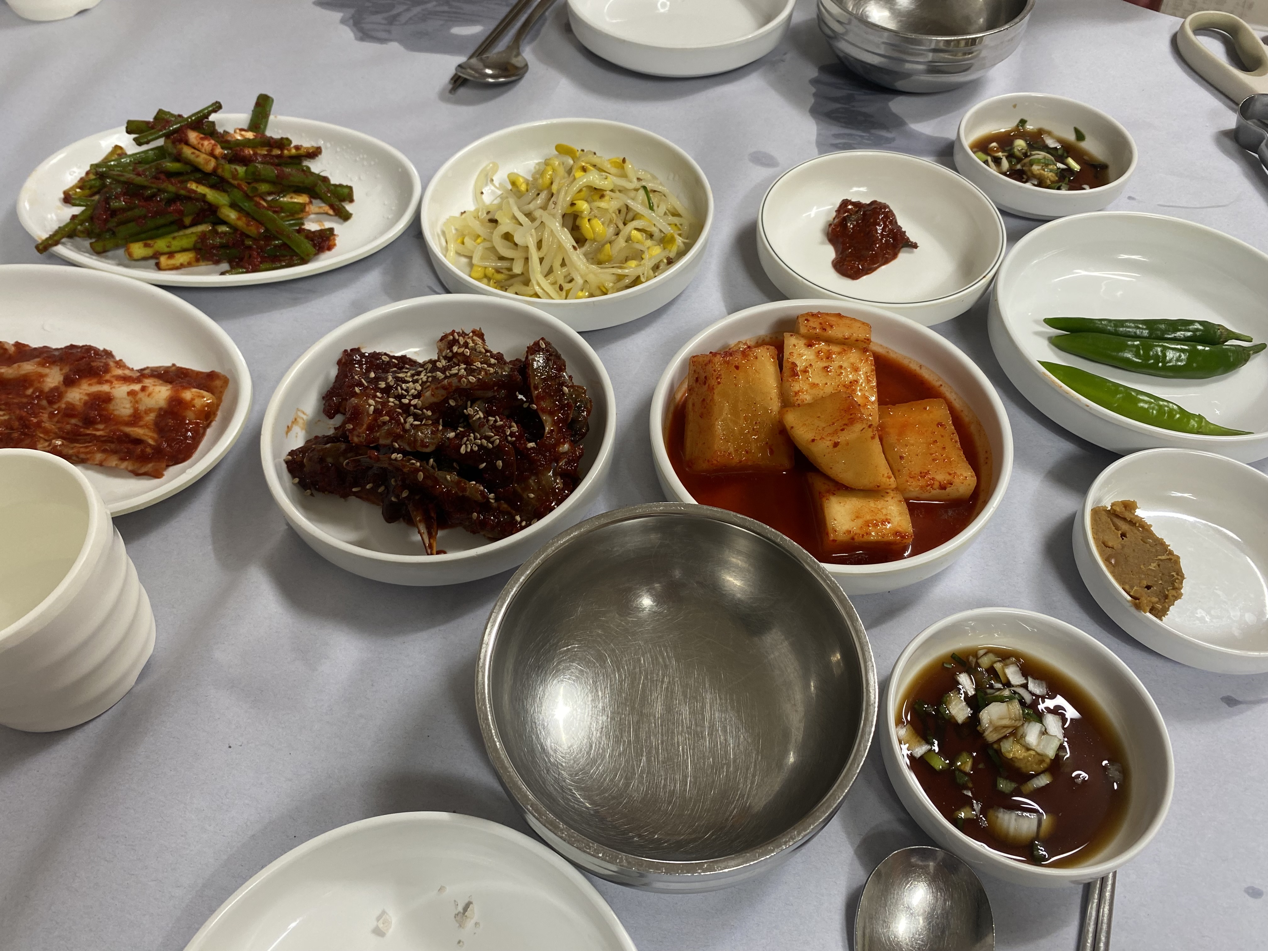 흰 접시에 나뉘어 나온 반찬과 위쪽 가운데의 콩나물